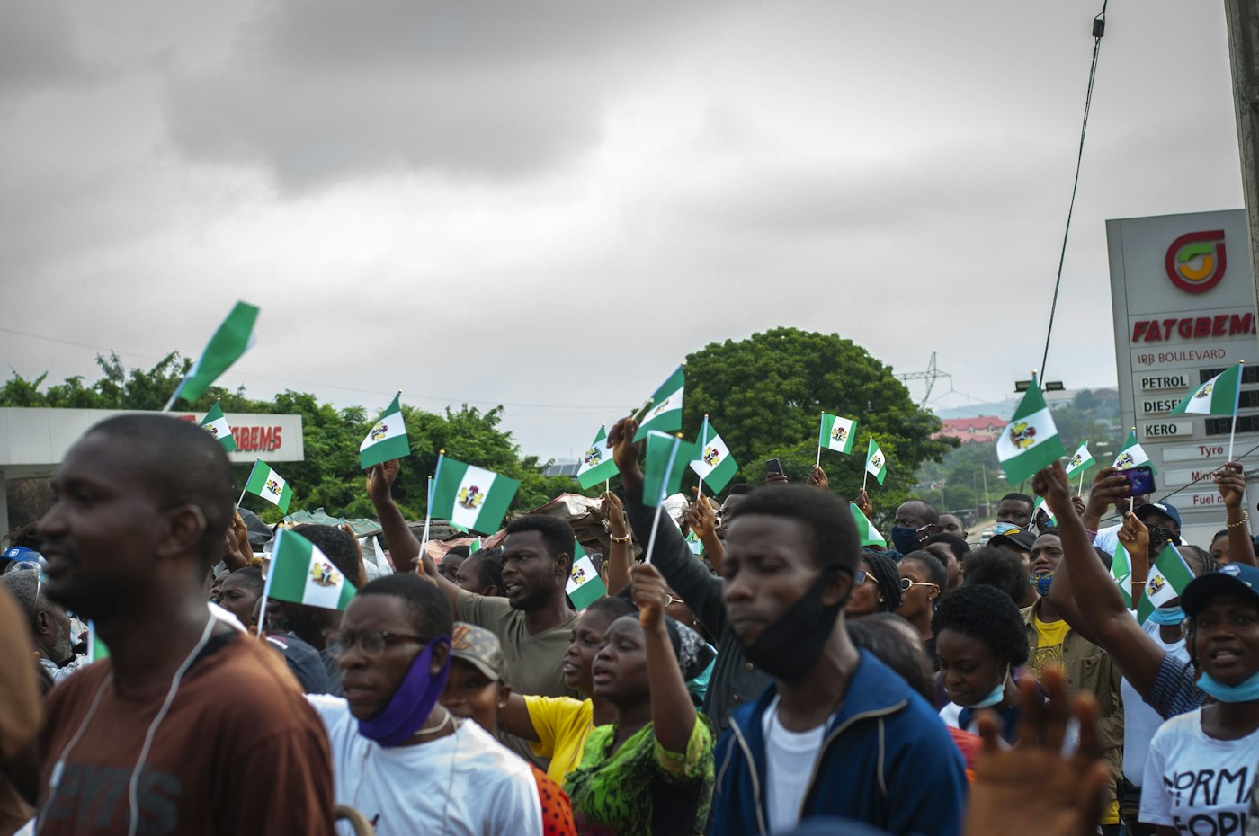 Young Nigerians at a rally, waving small Nigerian flags